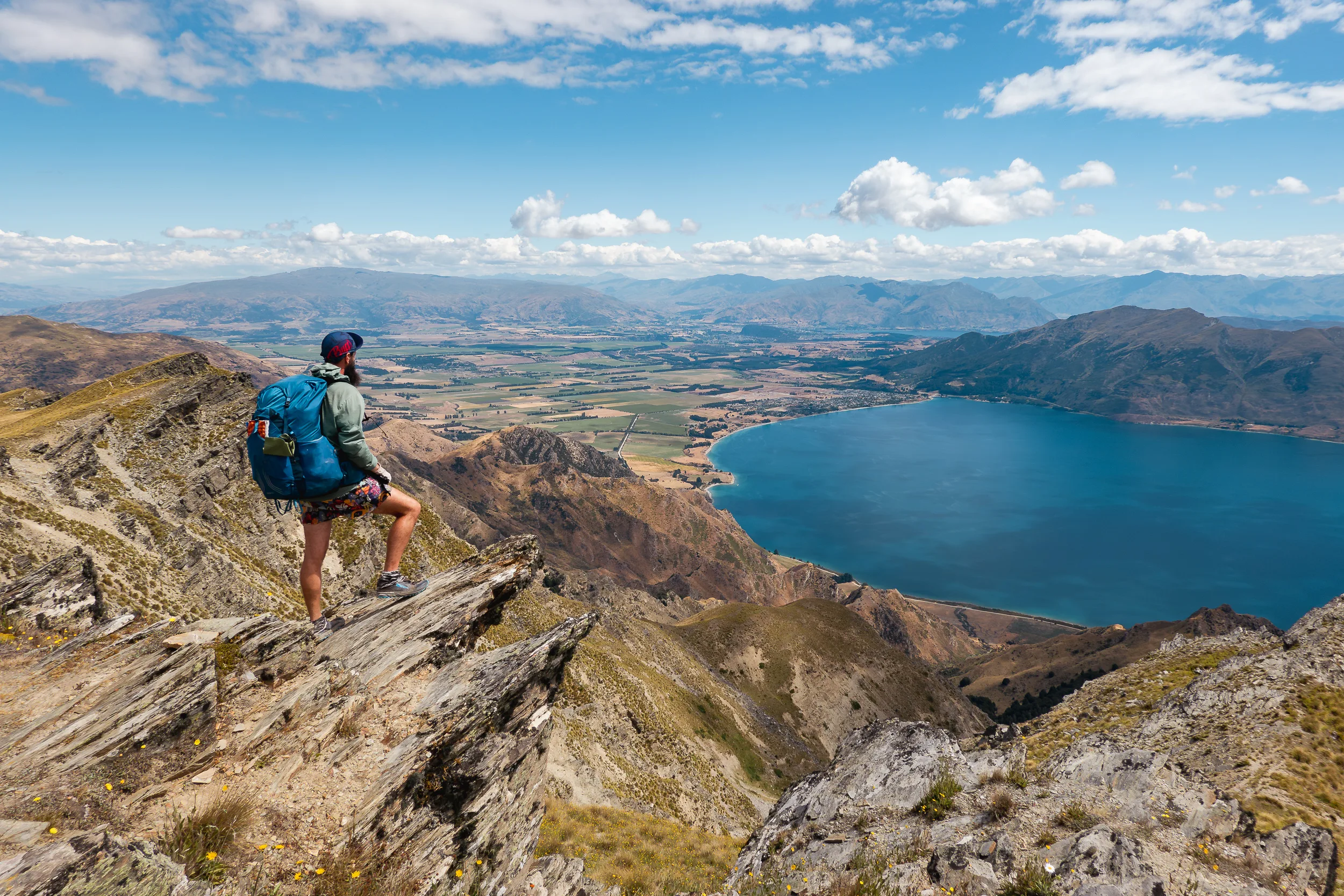 Wanderer auf Felsen mit Aussicht in Bucht